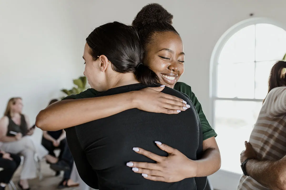 two women hugging after seeking 3 traits to look for in an alcohol recovery program and finding them