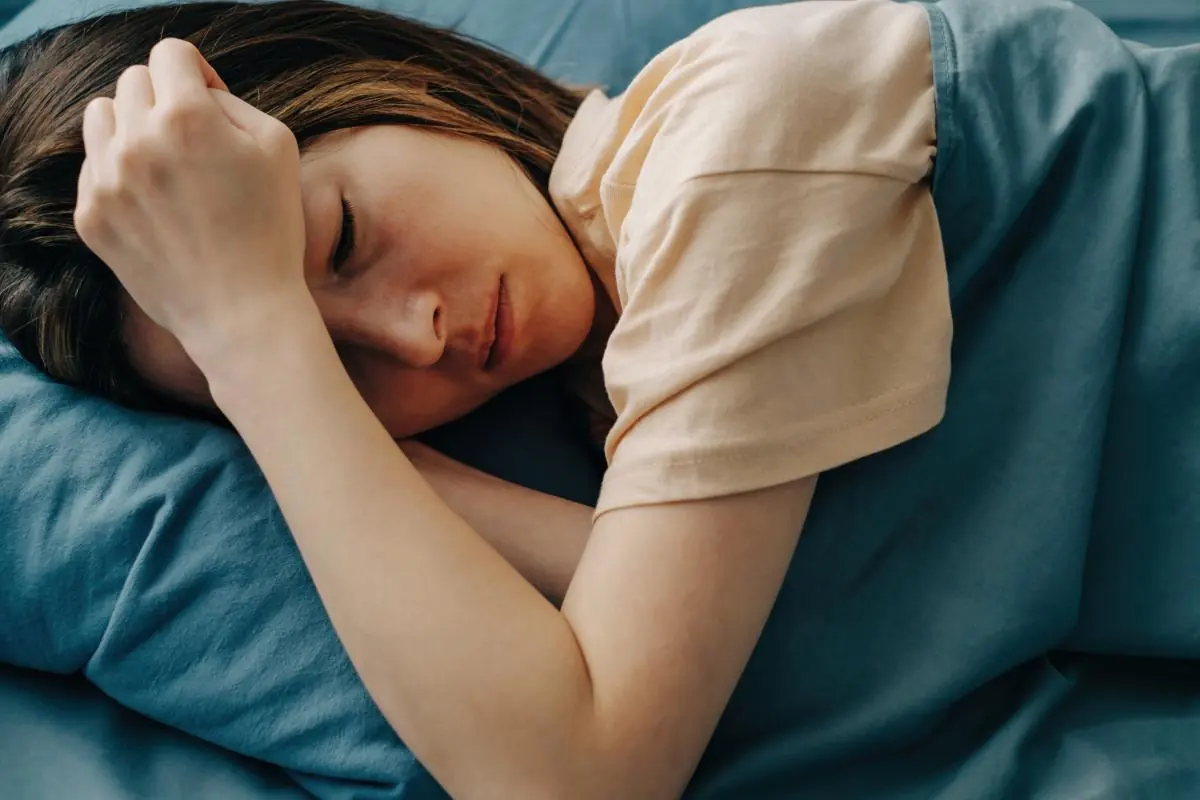 worried looking woman lying in bed wondering am i addicted to sleeping pills