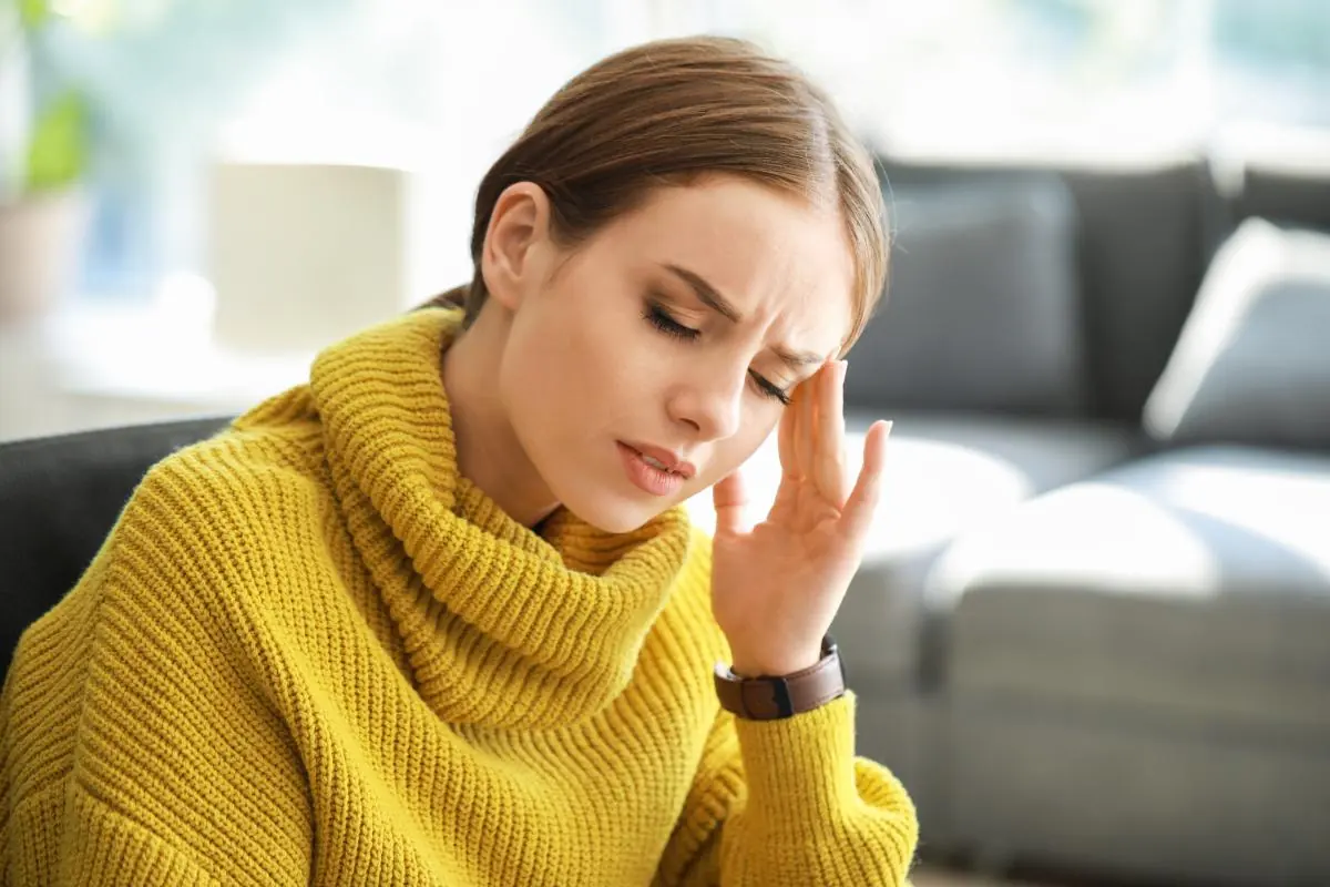 young woman with pained expression experiencing loperamide side effects