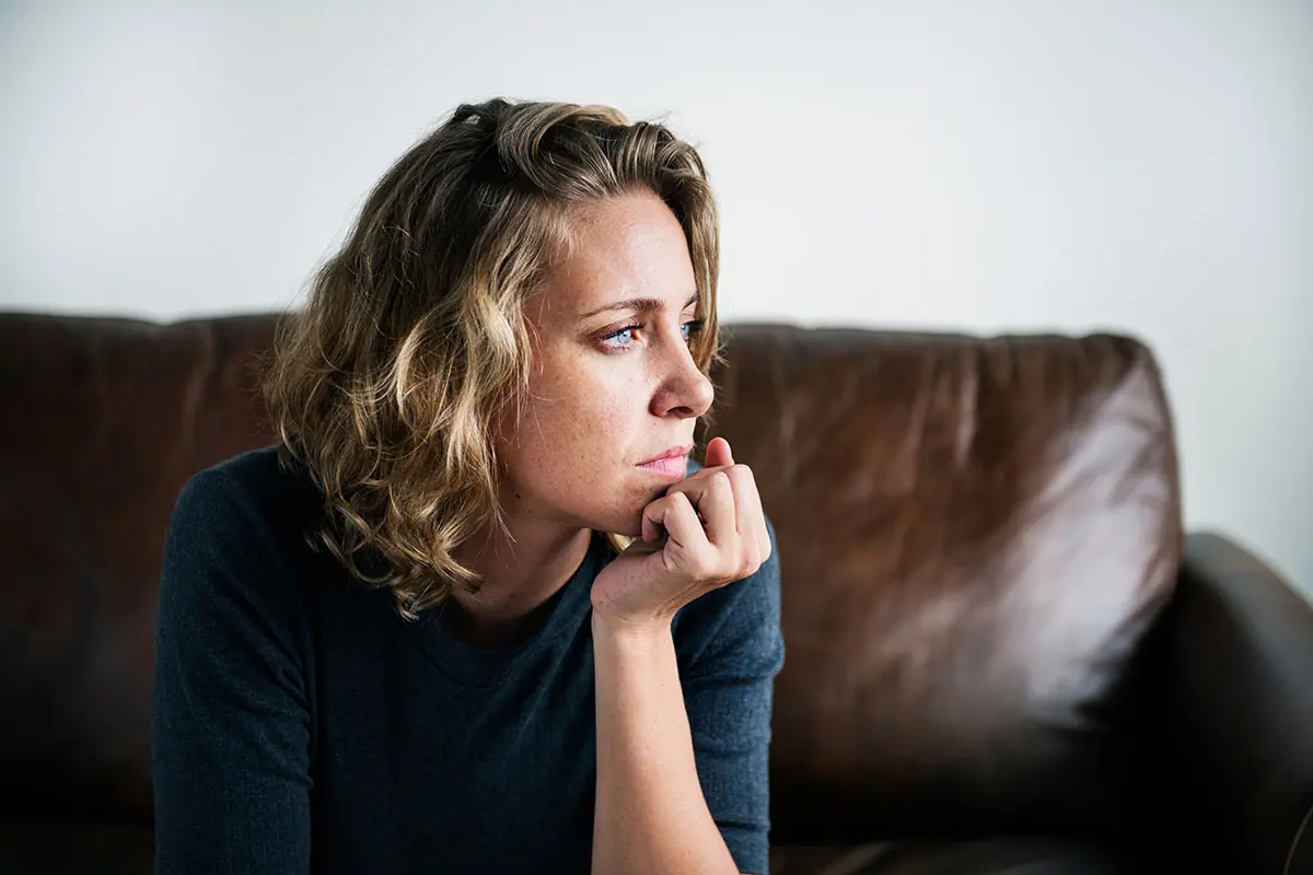 young woman sitting on couch looking thoughtful and wondering do i have a benzo addiction