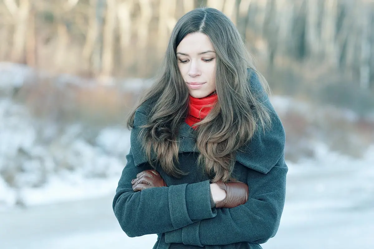 young woman outside on winter's day thinking of the 7 tips for making it through the holidays in recovery