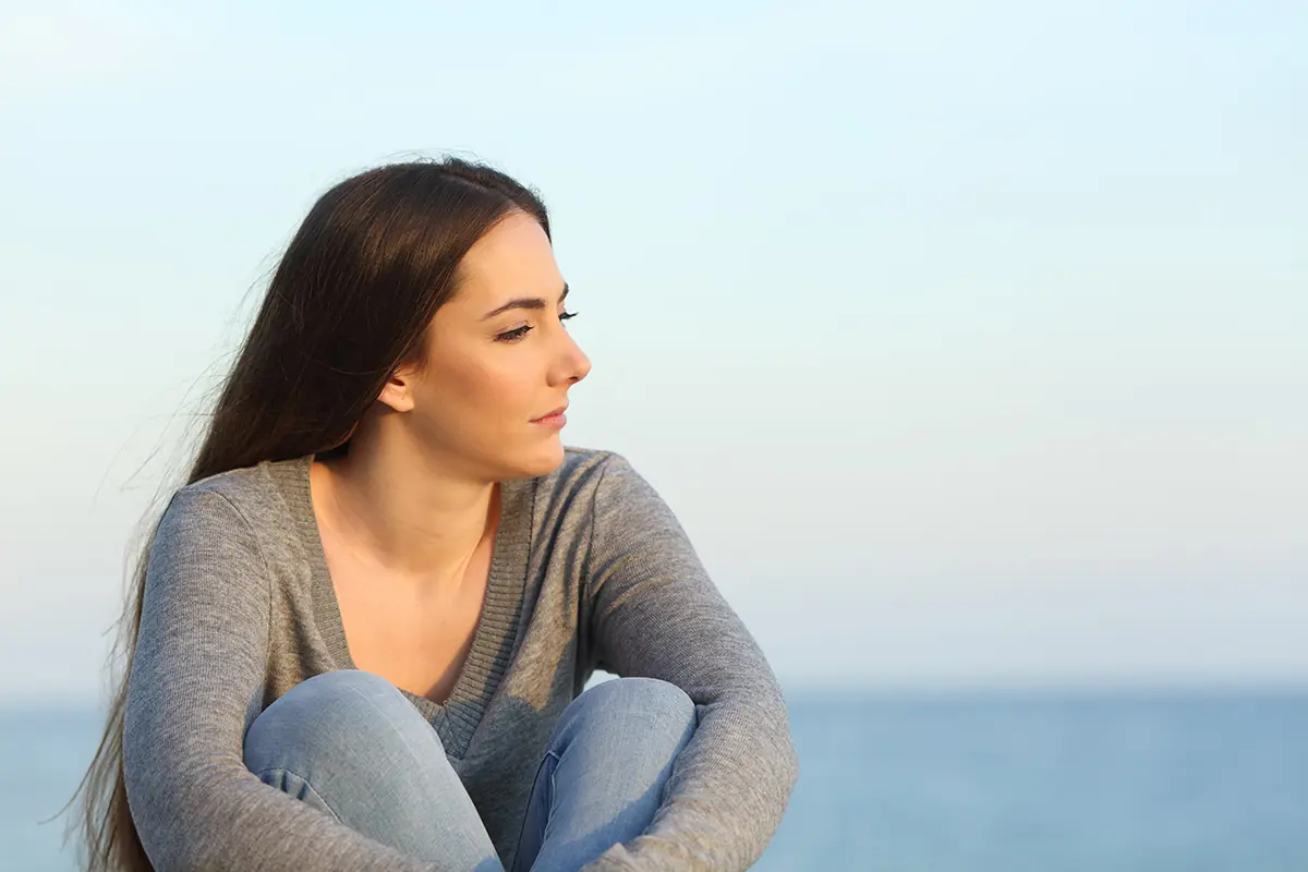 a woman considers the signs of alcohol addiction