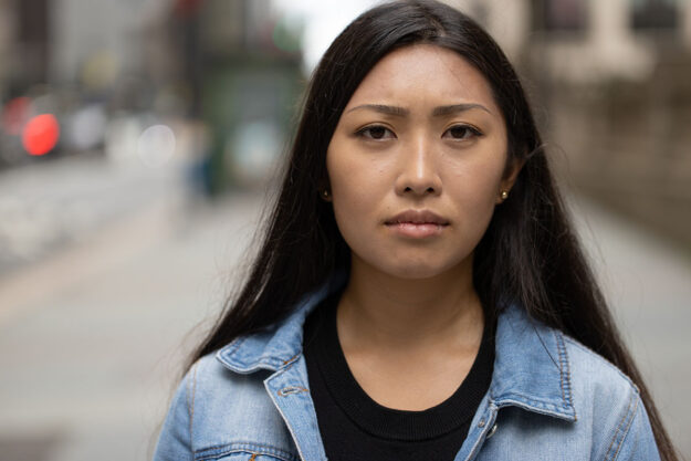 The Dangers of and Risks of Heroin Addiction in Women young serious looking woman walking down the street unaware of the dangers and risks of heroin addiction in women