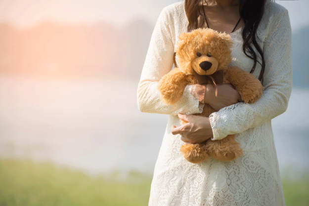The-Connection-Between-Childhood-Trauma-and-Addiction a woman holding a teddy bear reflects on how her childhood trauma led her to addiction