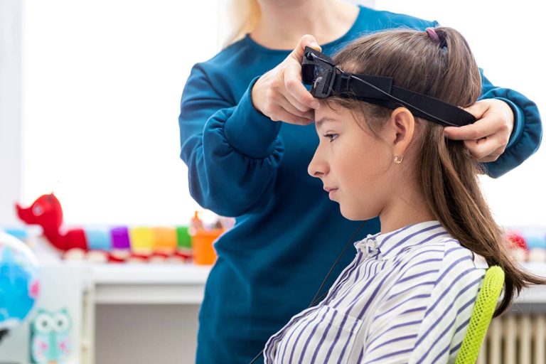 Young teenage girl and child therapist during EEG neurofeedback session. Electroencephalography concept. learning how a neurofeedback treatment program works