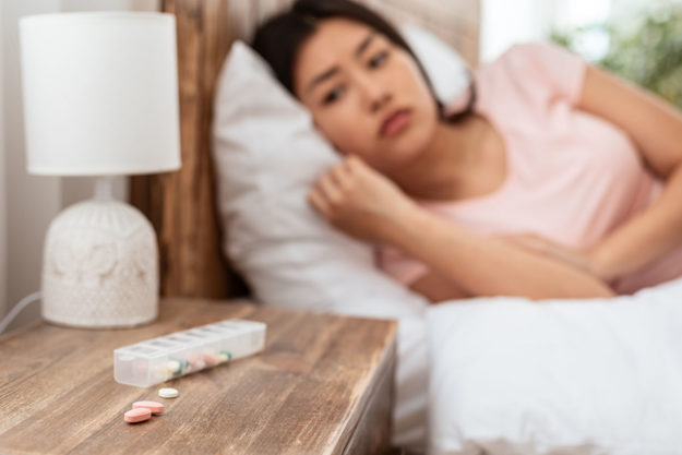 Asian Girl Taking Sleeping Pills Having Insomnia Lying In Bed woman who wants to stop relying on sleeping pills
