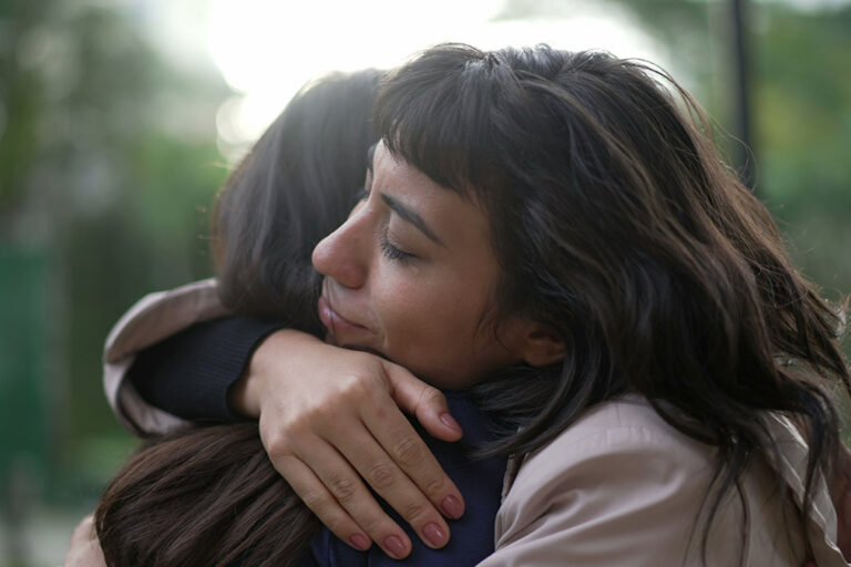 two women hugging after asking does your loved one have a prescription drug addiction