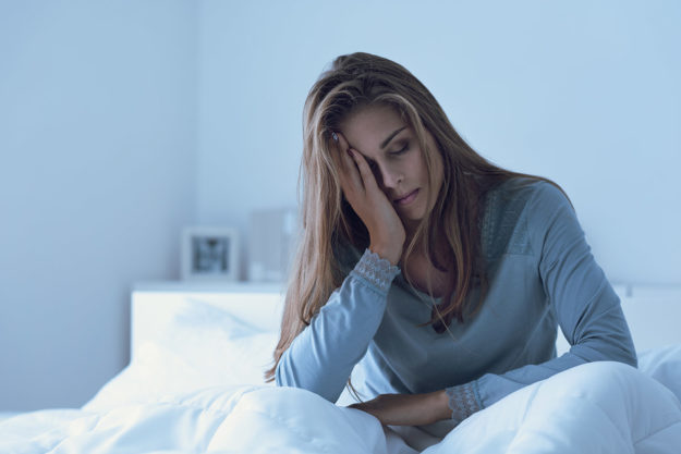 Long-term Side Effects of a Sleeping Pill Addiction a tired woman in bed struggles with the long-term side effects of sleeping pills