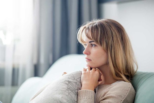 Gray-Area-Drinking-The-Sneaky-Substance-Use-Problem-That’s-on-the-Rise woman on couch thinking about gray area drinking