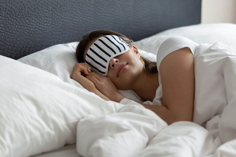 8 Natural Sleeping Aids Someone wearing a sleep mask and experiencing the effects of natural sleeping aids
