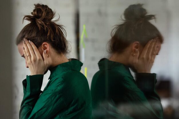 The Dangers of Combining Gabapentin and Opioids a woman holds her head after researching effects of gabapentin and opioids