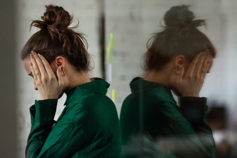 a woman holds her head after researching effects of gabapentin and opioids