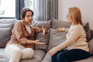 female therapist helps younger female client in a professional office setting as part of a women's treatment center for substance use disorder and co-occurring mental health issues