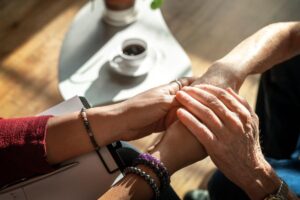 therapist holding the hands of an elderly client who is seeking Ativan rehab and treatment in Colorado