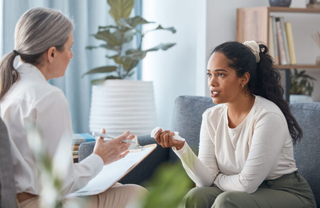 Navigating Triggers female therapist explaining to young woman about navigating triggers and executive functioning during recovery
