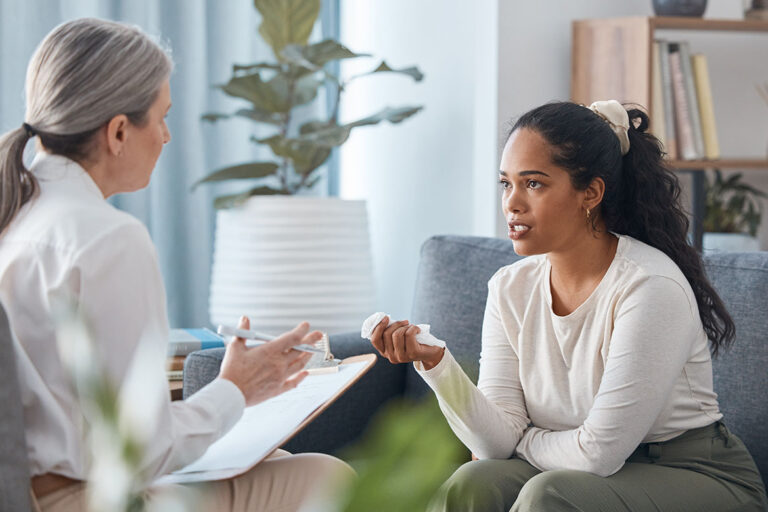 female therapist explaining to young woman about navigating triggers and executive functioning during recovery