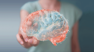 A woman presents a blue and red brain, highlighting the role of transcranial magnetic stimulation in therapy
