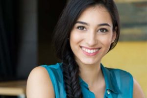 A woman in a blue shirt with long hair, contemplating her path to recovery from addiction