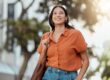 young woman smiling as she walks outside on a sunny day after practicing 3 self-care tips for mental health