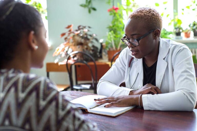 What-to-Expect-After-TMS-Treatment- female behavioral health specialist meeting with young woman in an office setting to explain what to expect after TMS treatment.