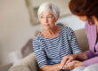 middle-aged woman seated on the couuch with her older mother wondering what to do when your mom drinks too much
