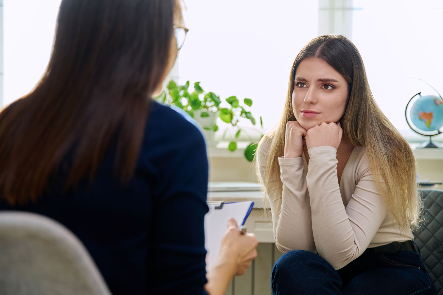 How to Treat PTSD in Women – Women’s Recovery CO A woman with PTSD is being treated at Women's Recovery. She is leaning forward, listening to her therapist.