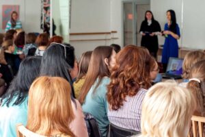 A group of women are sitting while participating in a drug and alcohol program for women in Colorado. They're listening to a presentation.