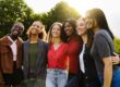 A group of women are standing outside with their arms around each other, smiling at the camera. They are enjoying the common understanding that makes a women's rehab program different.